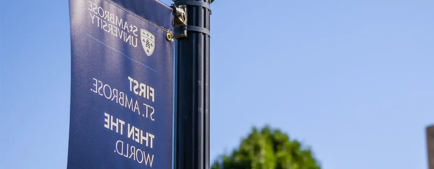 A St. Ambrose sign hanging from a post that reads 